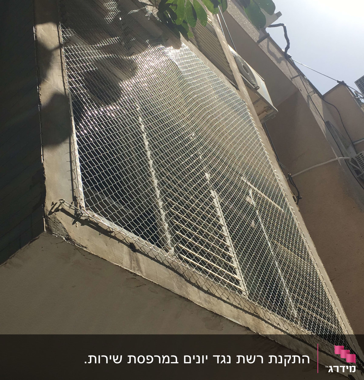 רשת מתכת מותקנת על חלון למניעת כניסת יונים